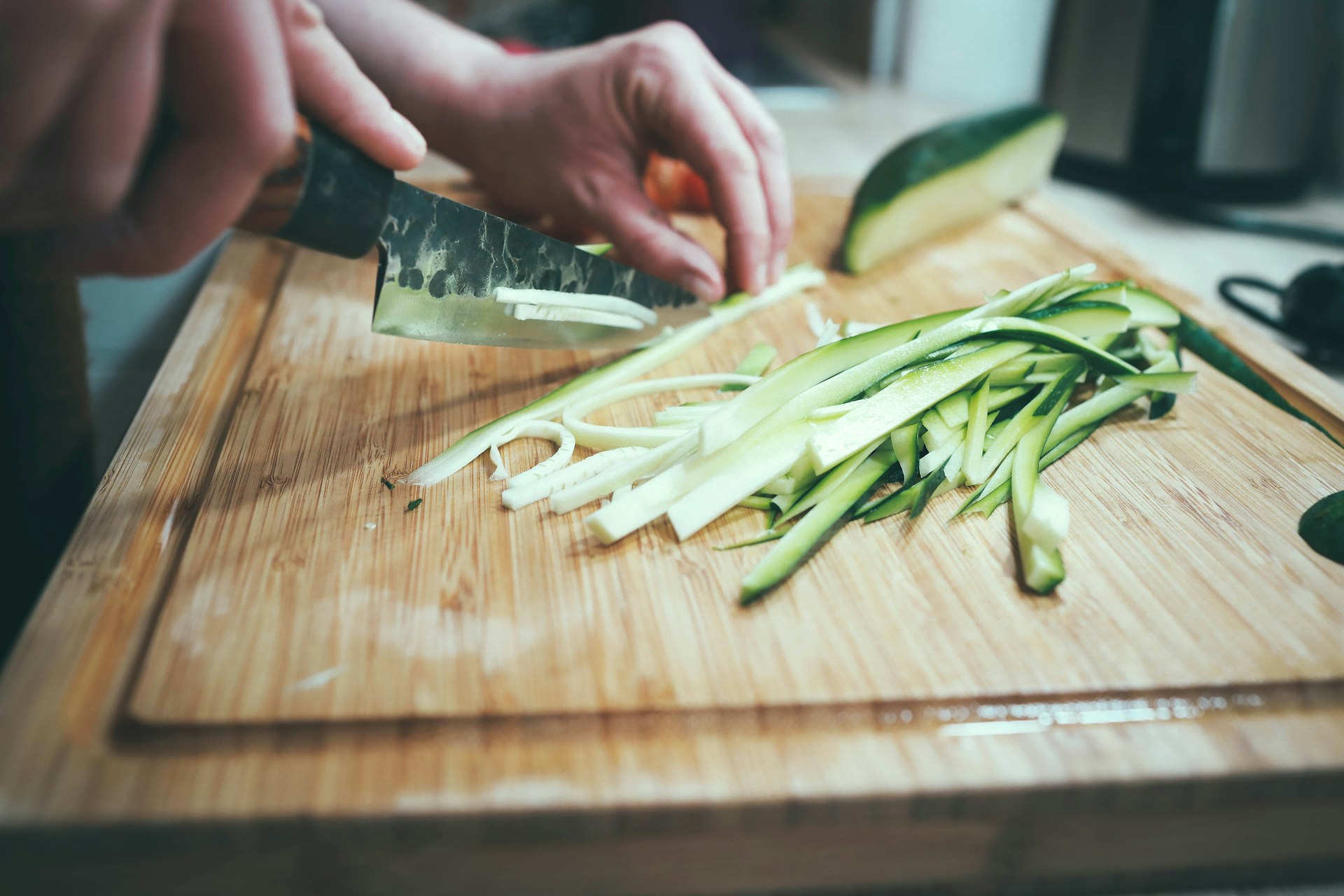 person slicing cucumber